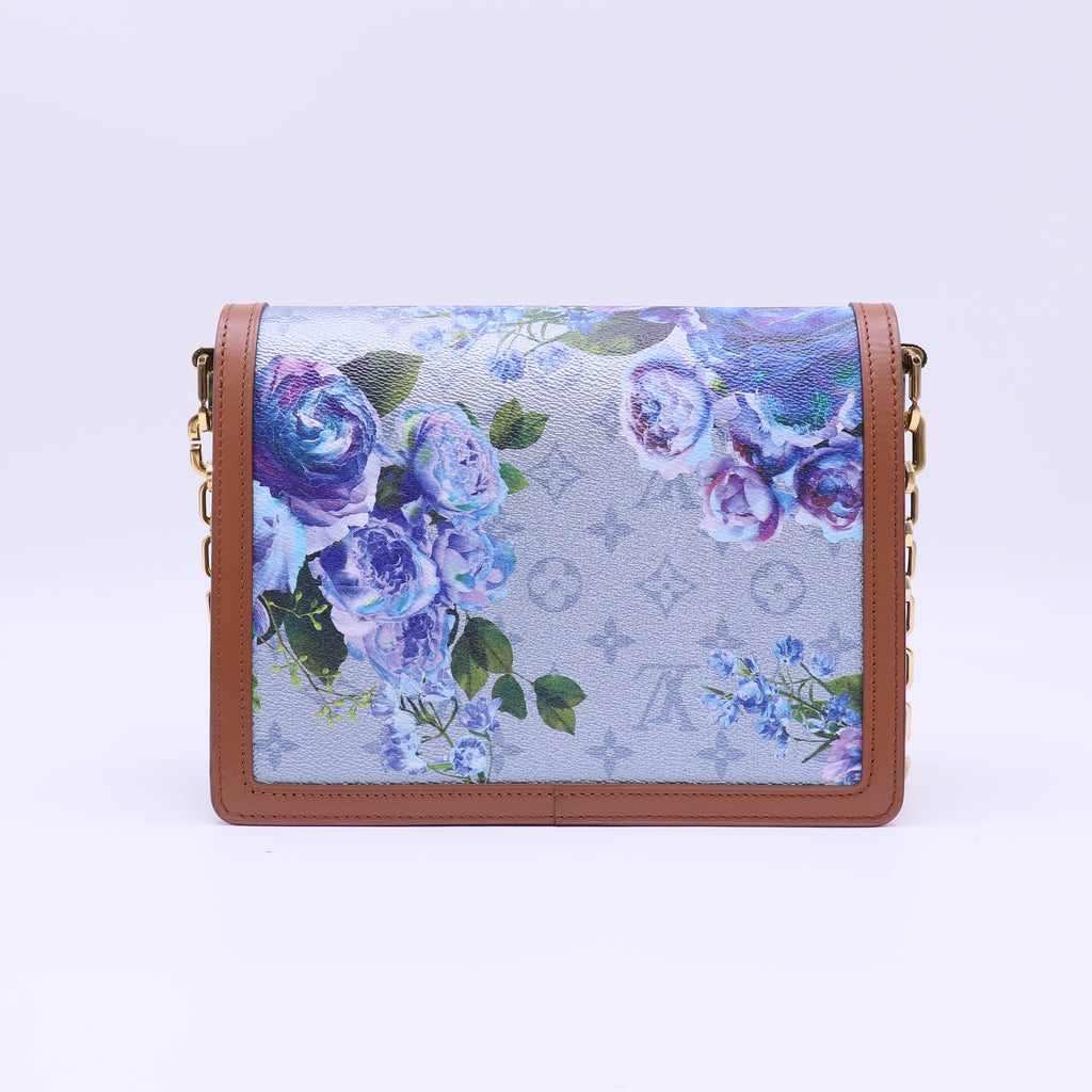 Louis Vuitton LV Garden Dauphine MM bag features a striking metallic blue monogram canvas with a floral print and natural leather trim